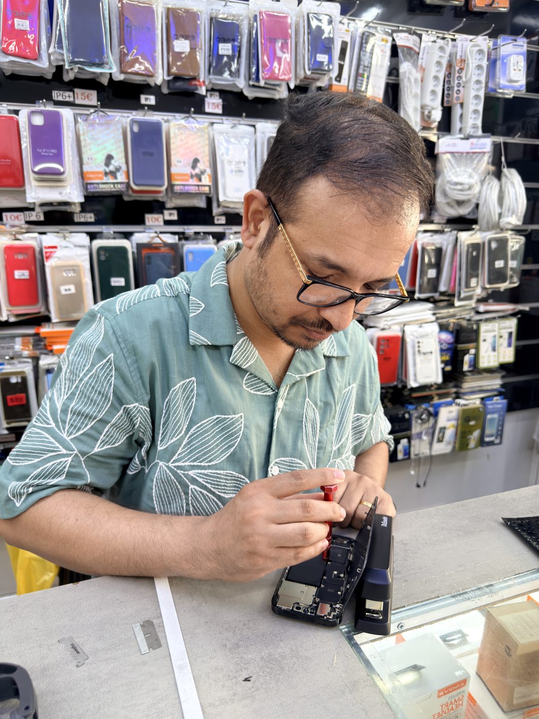 Technicien démontant un iPhone sur un établi de réparation