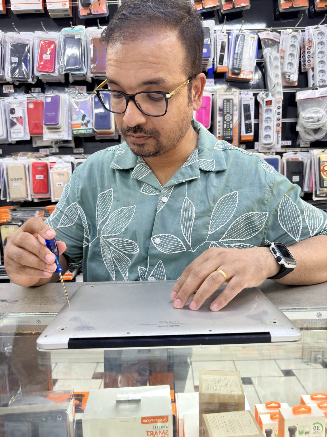 Technician repairing an open MacBook at a workbench