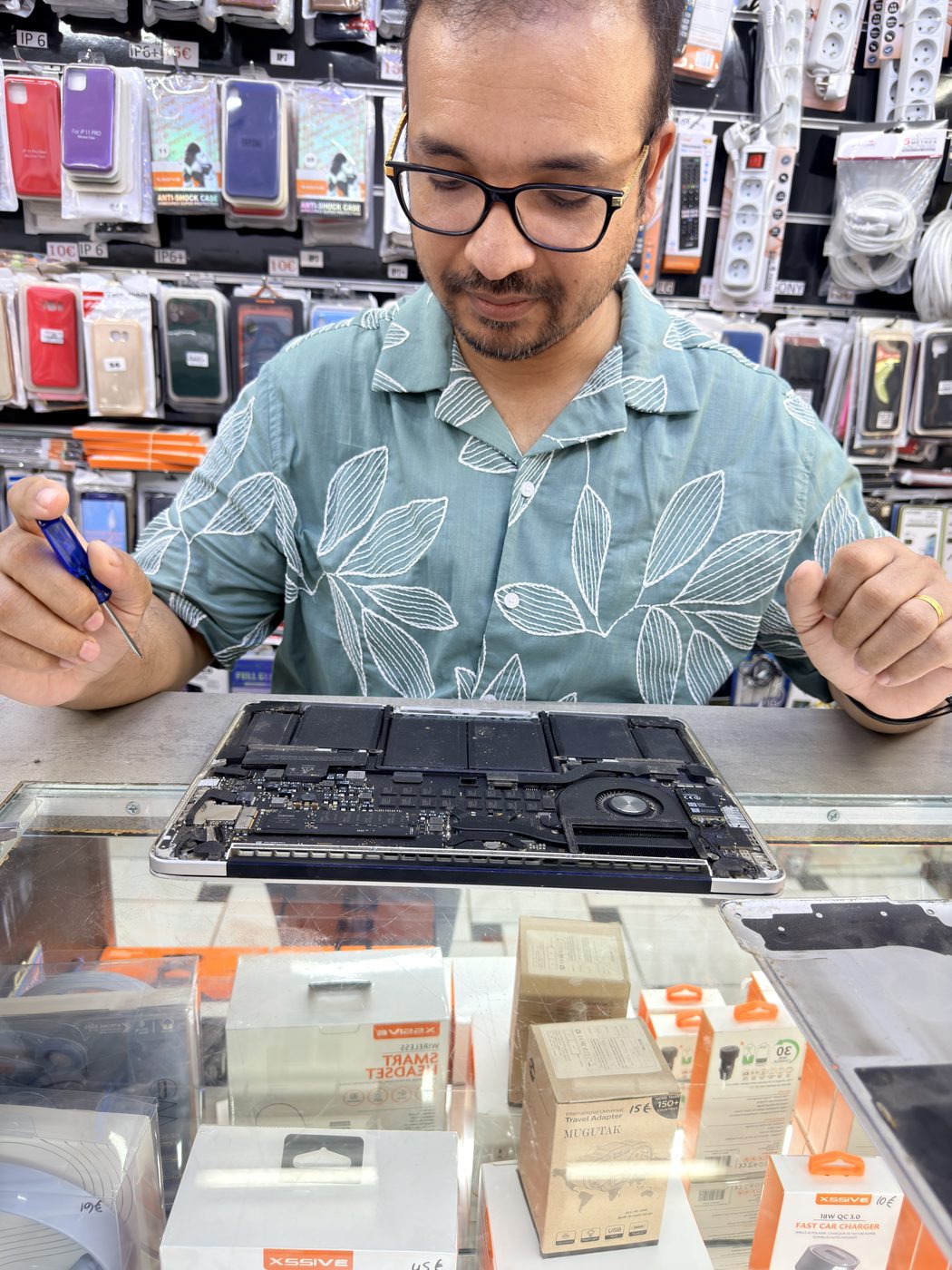 Technicien réparant un MacBook Pro sur un plan de travail