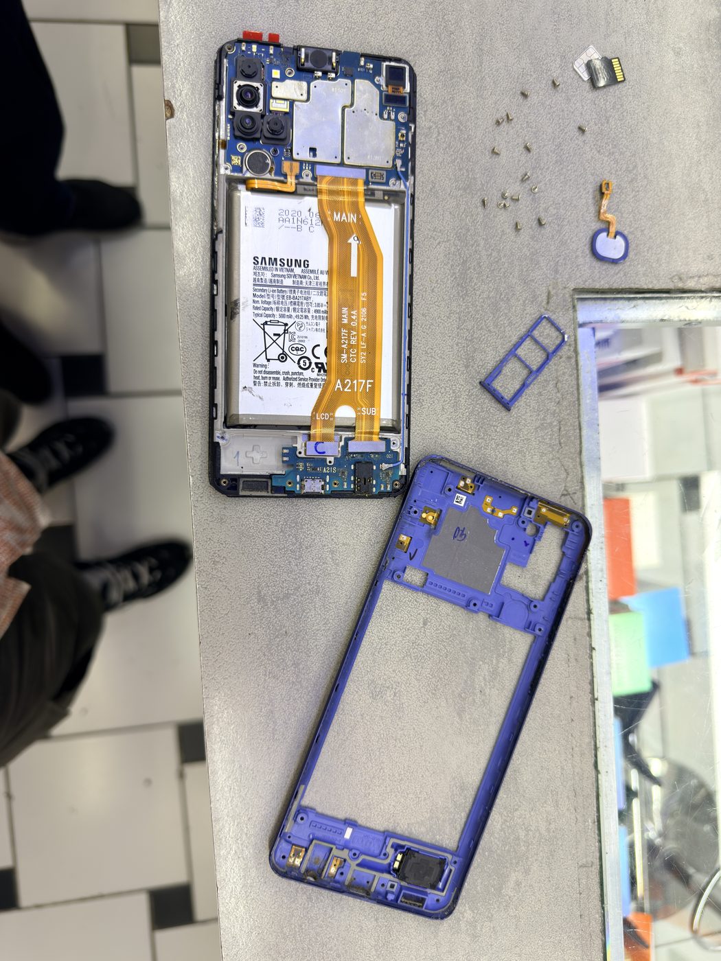 Samsung Galaxy A21s entièrement démonté sur un tapis de réparation