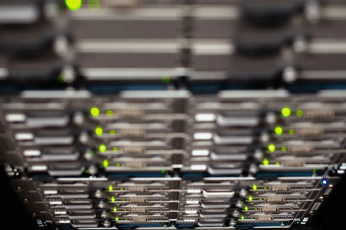 Close-up illustration of a data centre server rack with green status lights on the network equipment