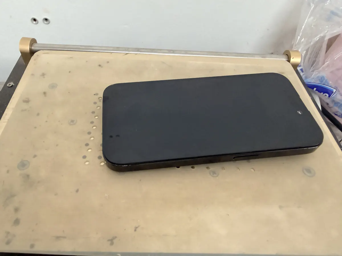 iPhone lying screen-up on a heated separator plate before display removal