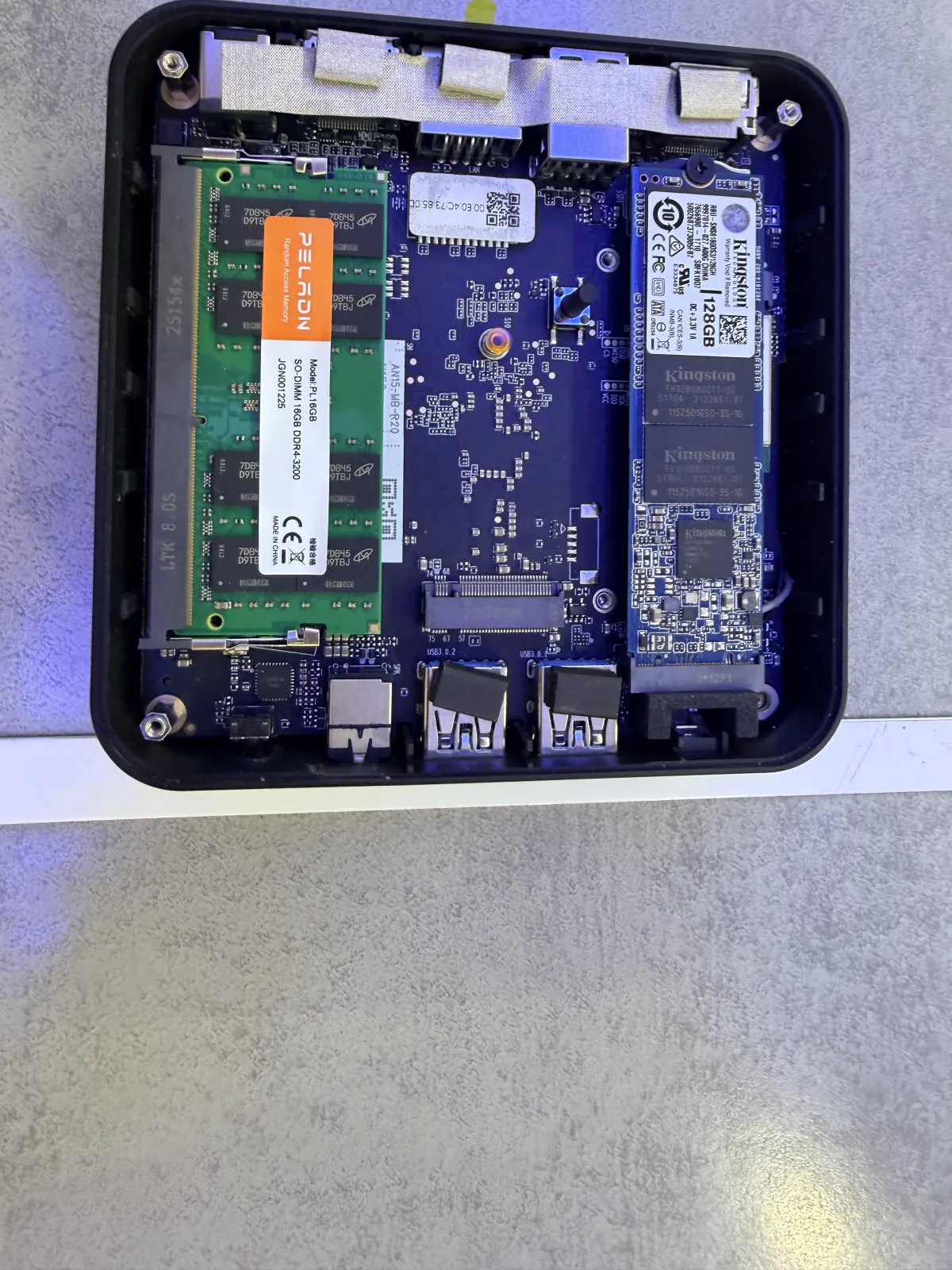 Interior of an open mini PC showing a SO-DIMM RAM stick and two Kingston M.2 SSDs installed